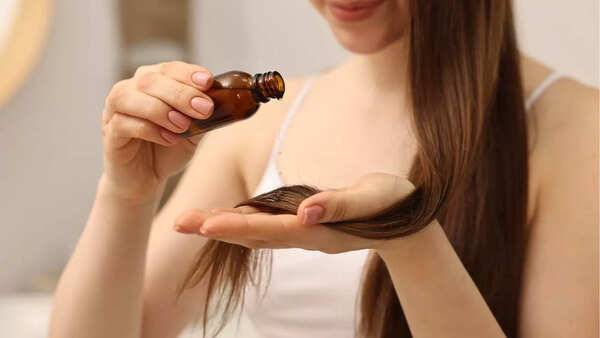 Woman applying hair oil to her hair